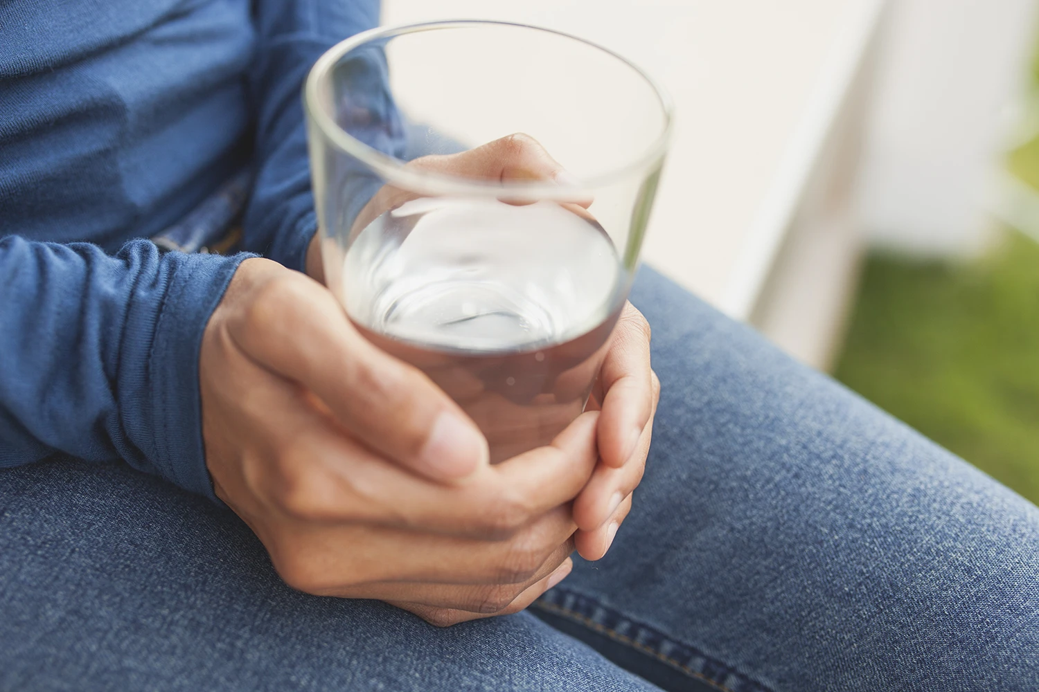 Glas mit klarem Wasser auf einer Tischfläche