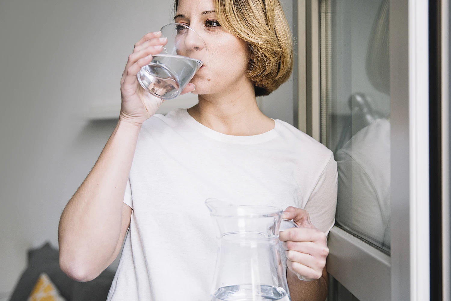 Person deckt ihren täglichen Wasserbedarf mit einem Glas Wasser